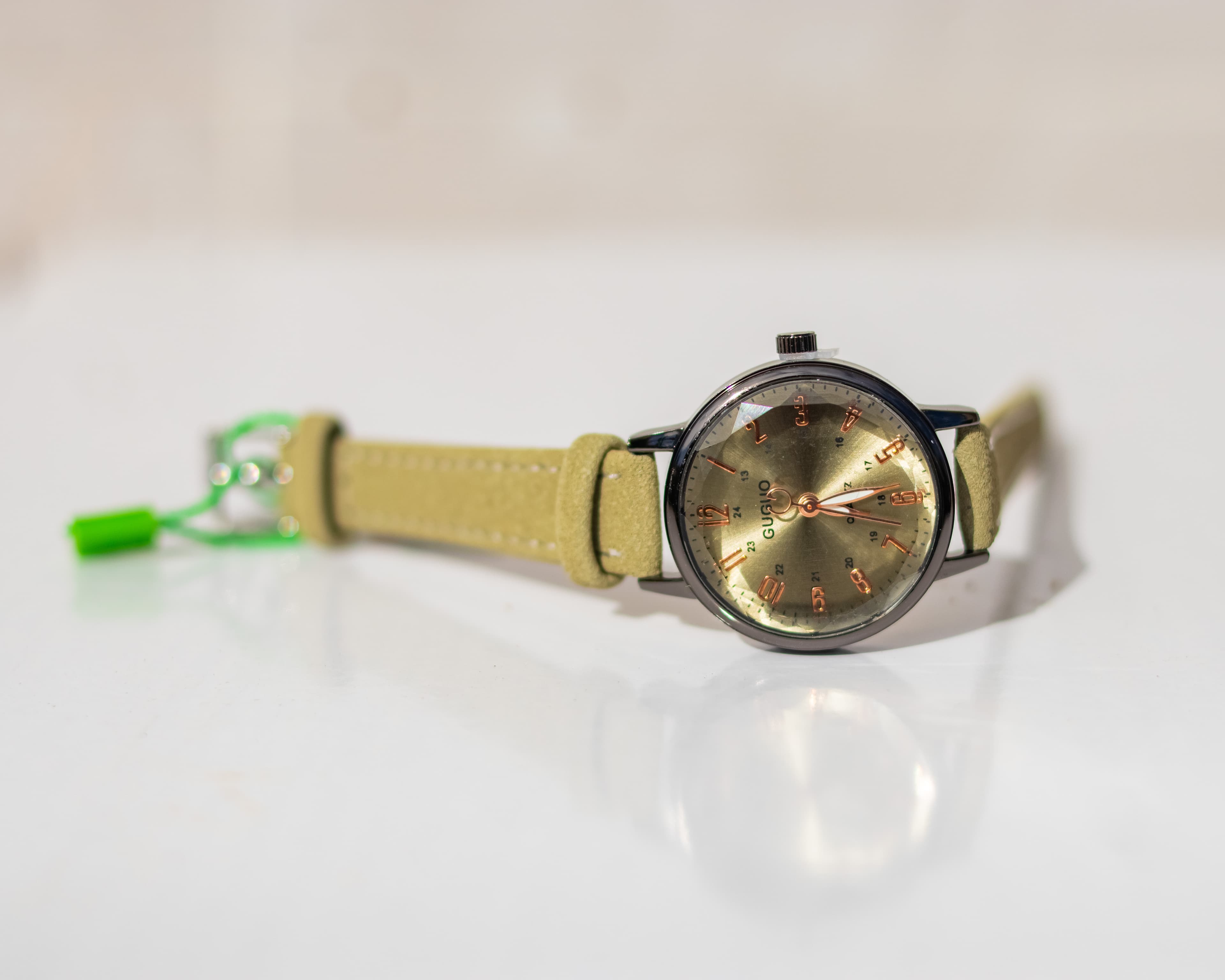 Crystal studded dial wristwatch with a white leather strap
