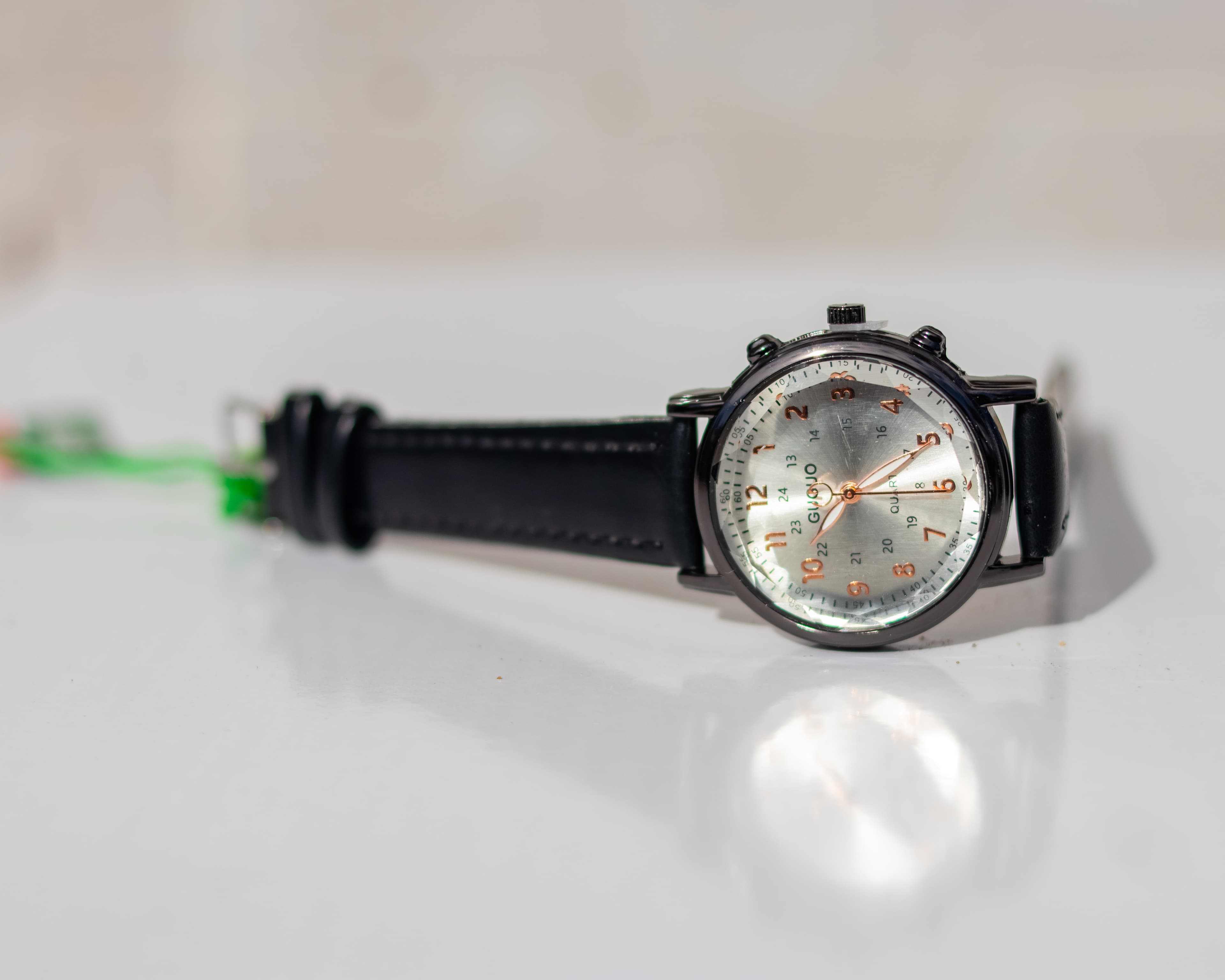 Crystal studded dial wristwatch with a black leather strap